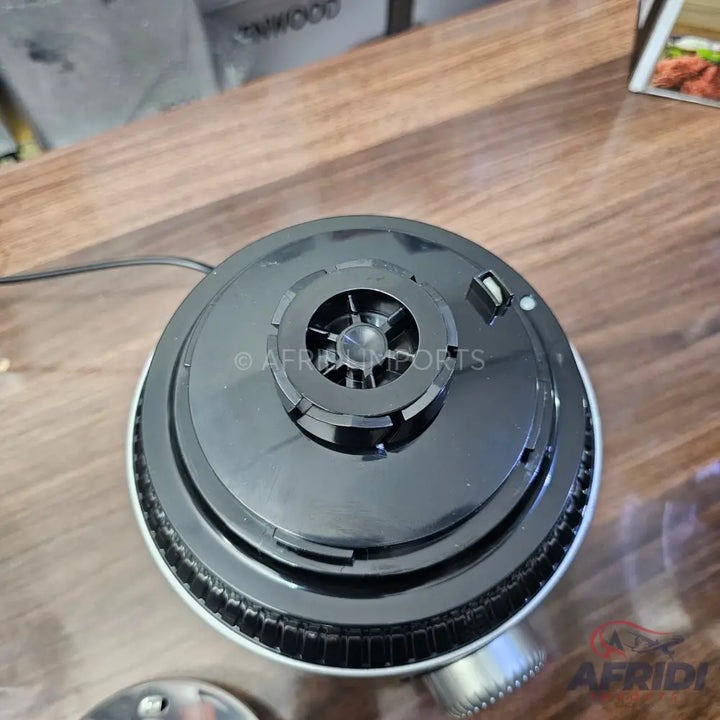 The black base of a kitchen appliance, likely a blender or stand mixer, with a central drive shaft and a ribbed, silver-colored rim.