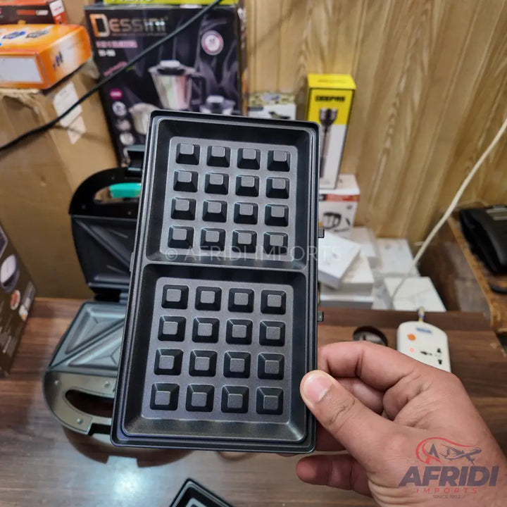 Black waffle iron plate with square grids.