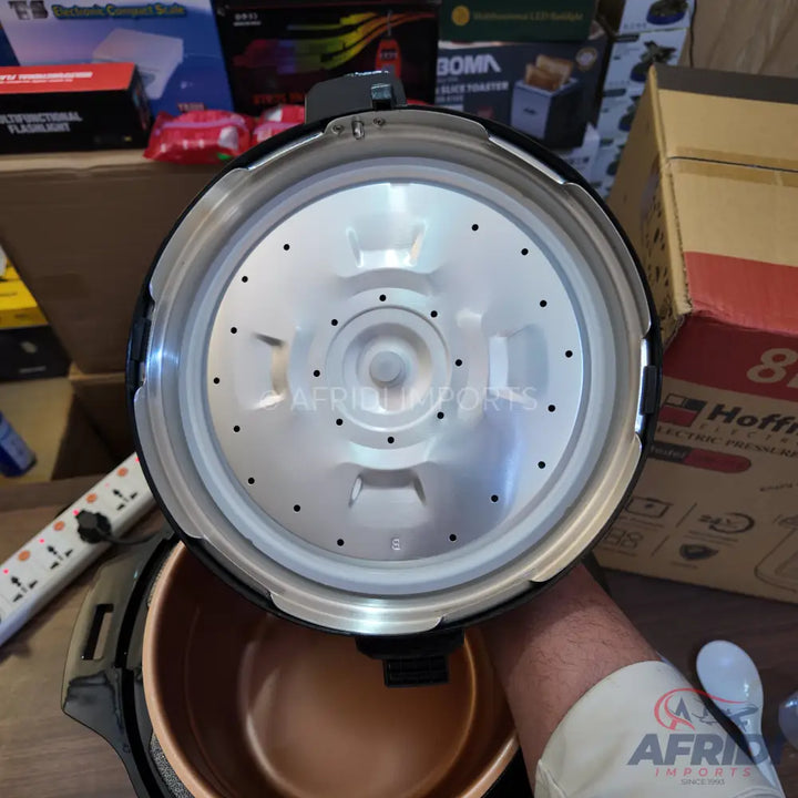 An open electric pressure cooker with a copper-colored inner pot.