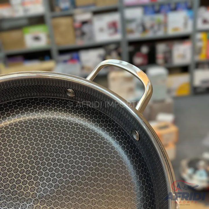 Hexagonal patterned non-stick frying pan with stainless steel handle.