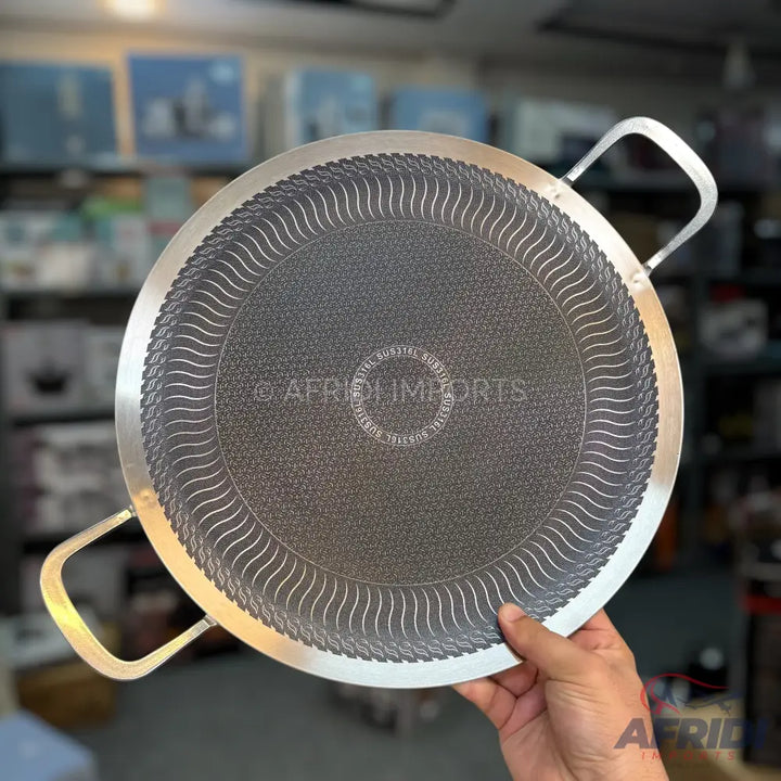 Round, flat, two-handled cooking griddle with a textured, non-stick surface.