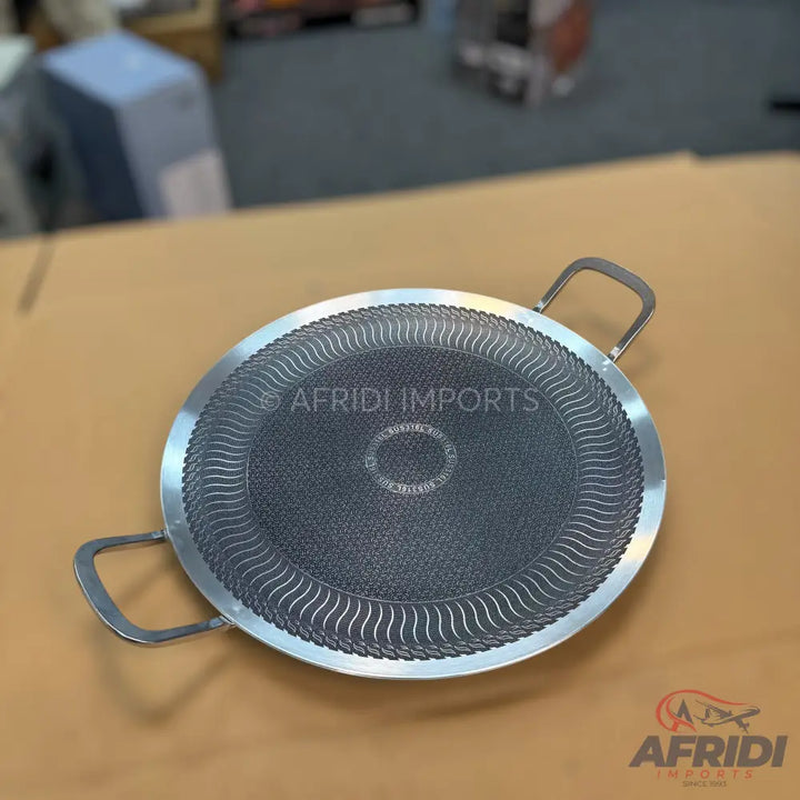Round, flat, non-stick griddle with two handles.
