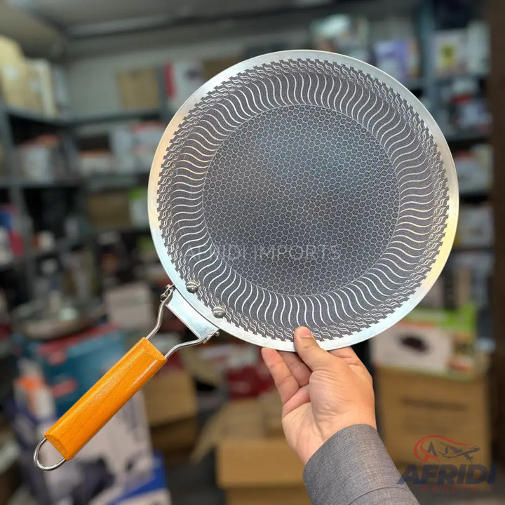 Round flat griddle with a textured surface and a single orange handle.