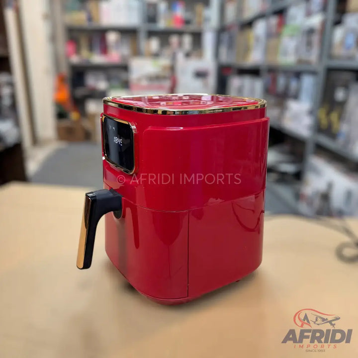 Red air fryer with a black and gold handle and a digital display.