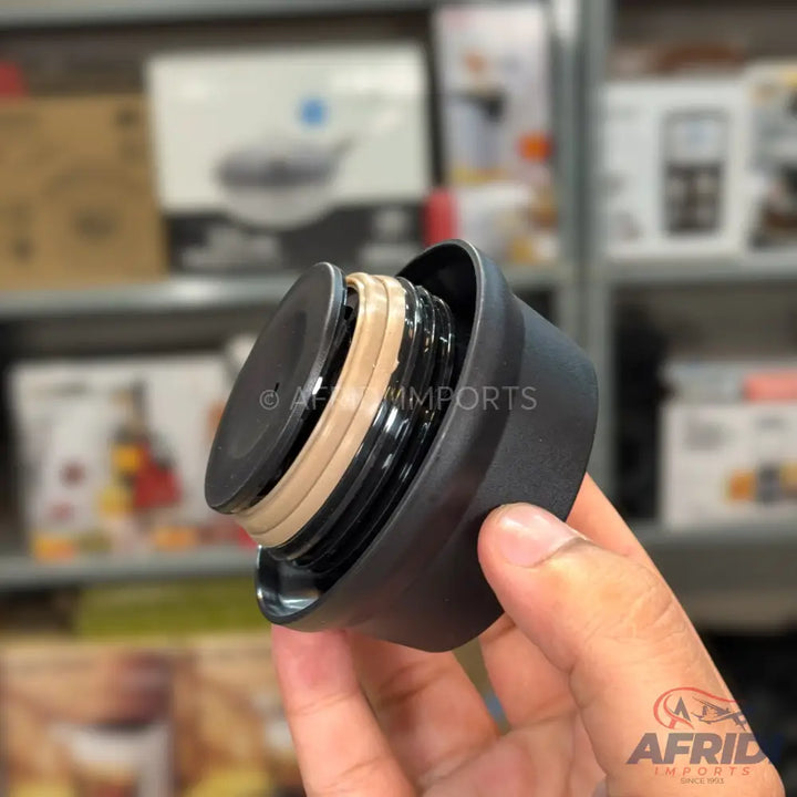 Black plastic lid with an internal screw thread and a light brown rubber seal.