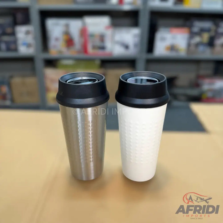 Two insulated travel mugs, one silver and one white with a textured surface, both with black lids.