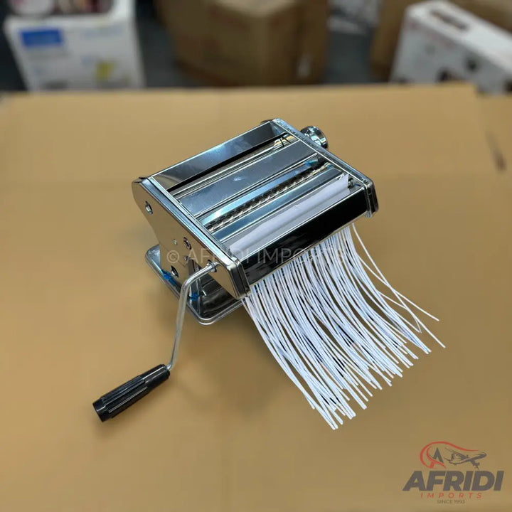 Stainless steel manual pasta maker with a black handle, producing thin white strands.