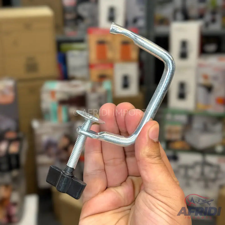 A metal C-clamp with a threaded screw and a black plastic knob.