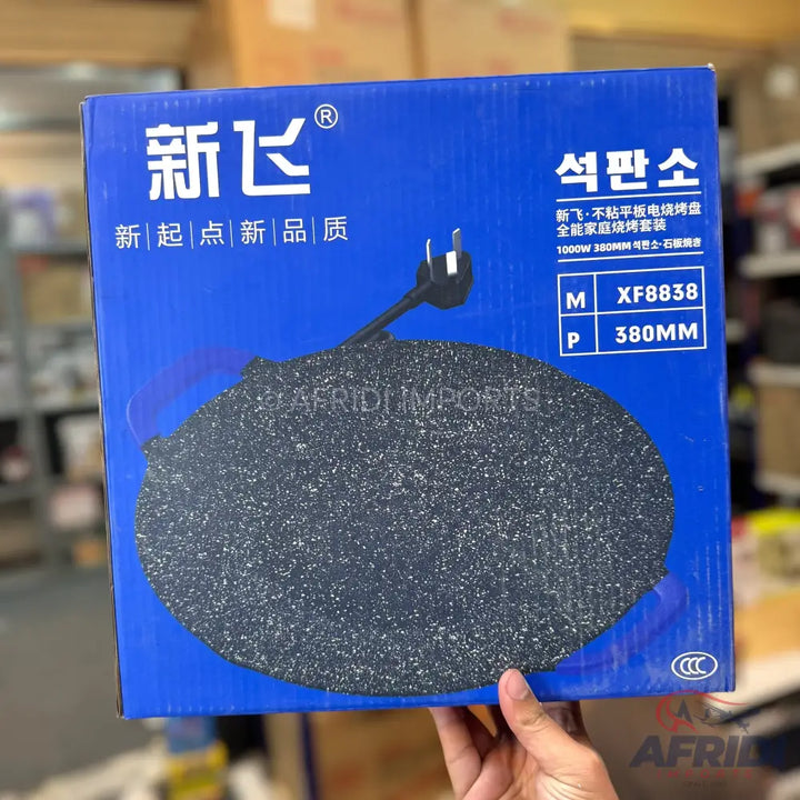Blue box containing a black speckled electric griddle.