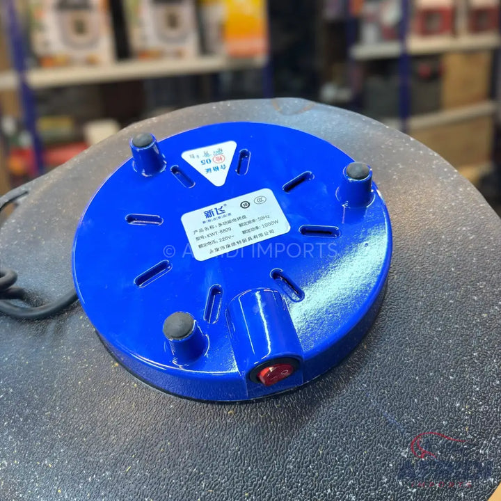 Blue electric hot plate with three rubber feet, a power switch, and a power cord.