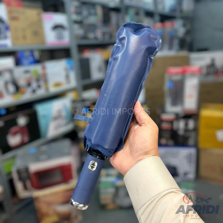 A blue automatic umbrella with a button on its handle.