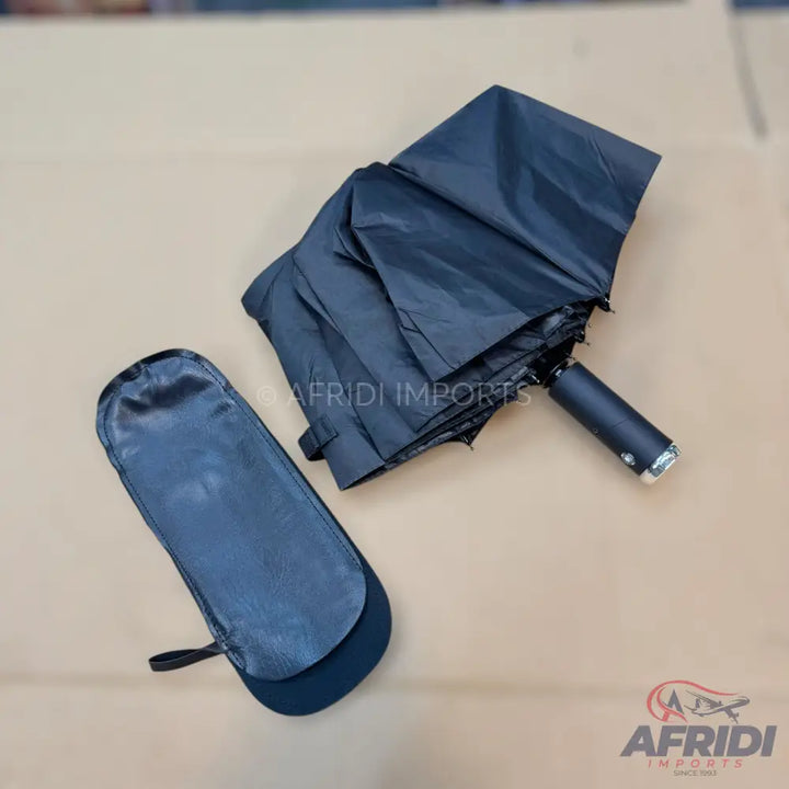 A black foldable umbrella with its matching carrying sleeve.