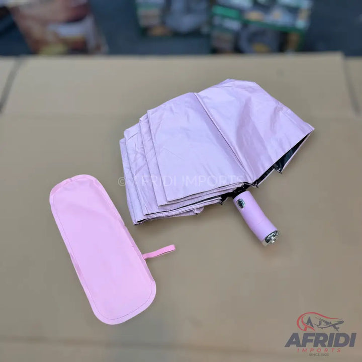 A folded pink umbrella with a matching sleeve.