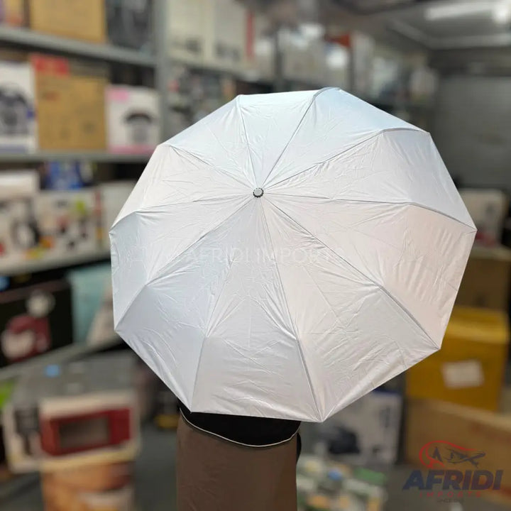 An opened, plain white, foldable umbrella with a silver interior.