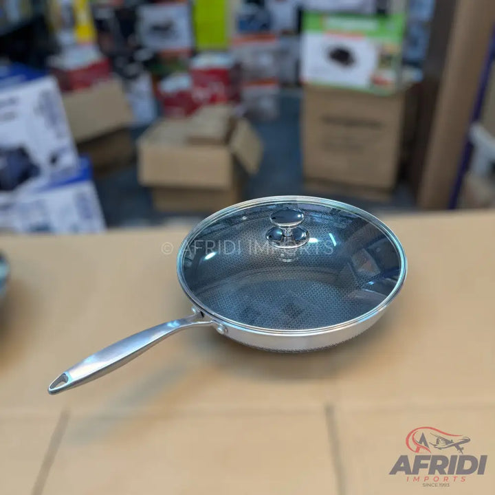 Stainless steel frying pan with a glass lid.