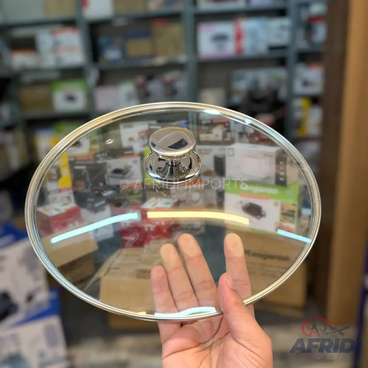 A clear glass pot lid with a silver-colored knob handle and a metallic rim.