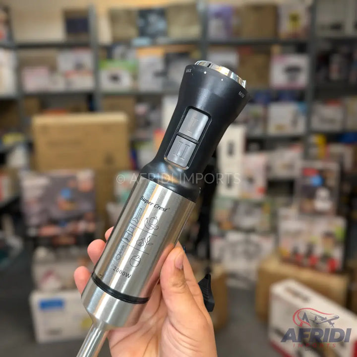 A stainless steel immersion blender with a black handle and two control buttons.