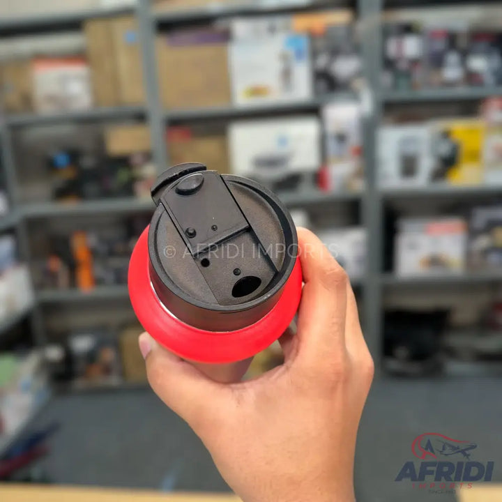 A red and black travel mug with a flip-top lid.