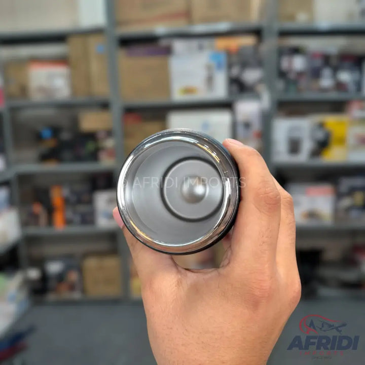 An open, stainless steel travel mug or tumbler with a silver interior.