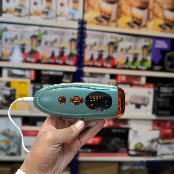 Handheld teal and orange IPL hair removal device with a digital display.
