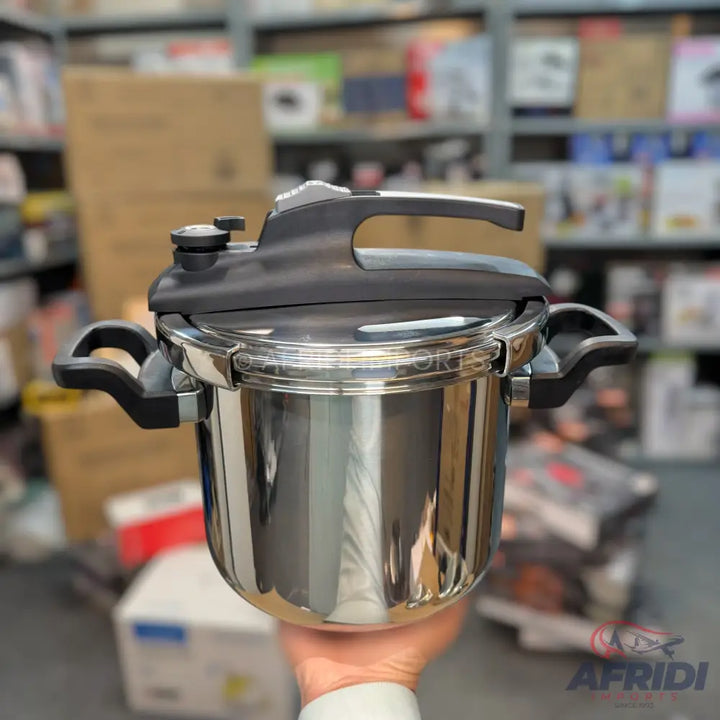 A stainless steel pressure cooker with black handles and lid.