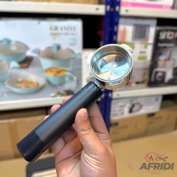 A black, handle-less portafilter with a shiny, silver-toned metal basket.