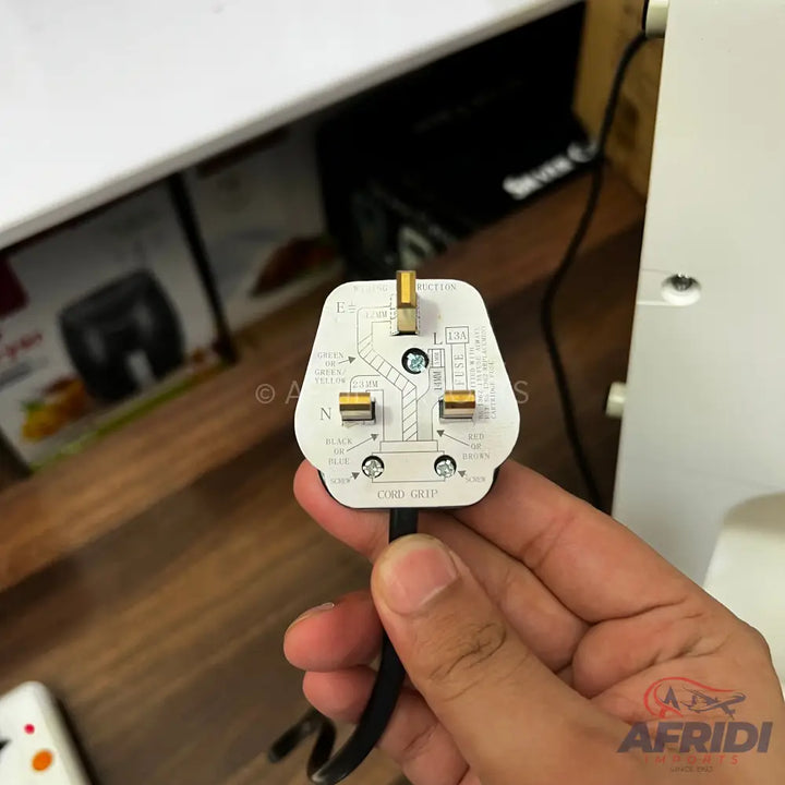 A white three-pin BS 1363 electrical plug with a black cord.