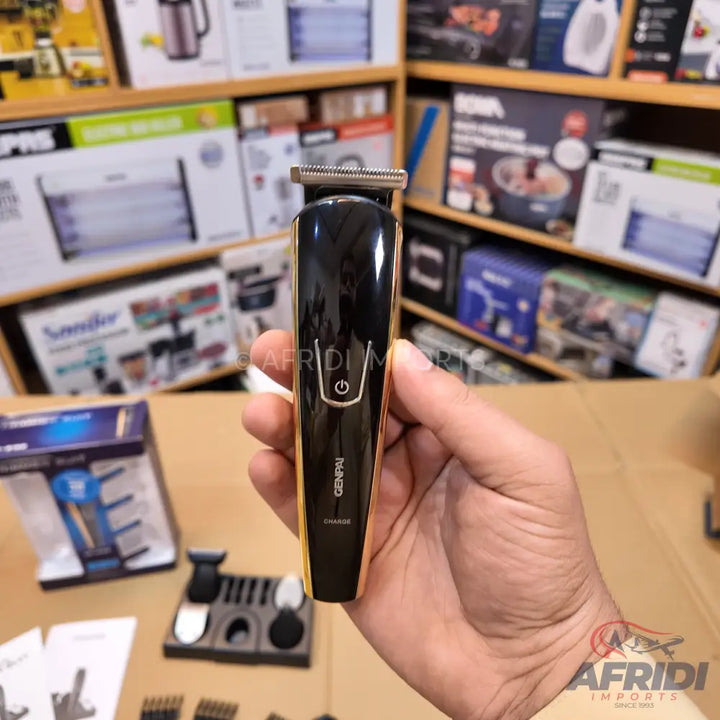 Black and gold electric hair trimmer with a power button and charging indicator.