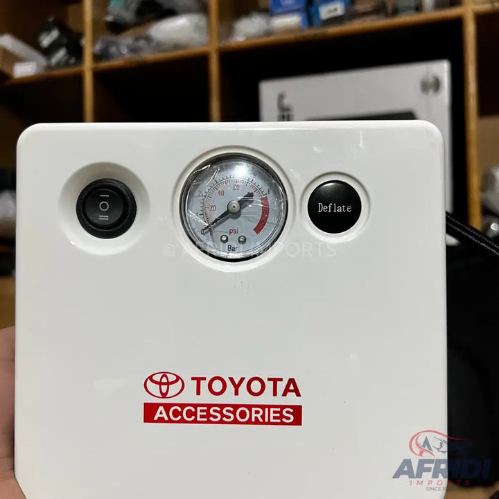 White portable air compressor with a pressure gauge and two control buttons.