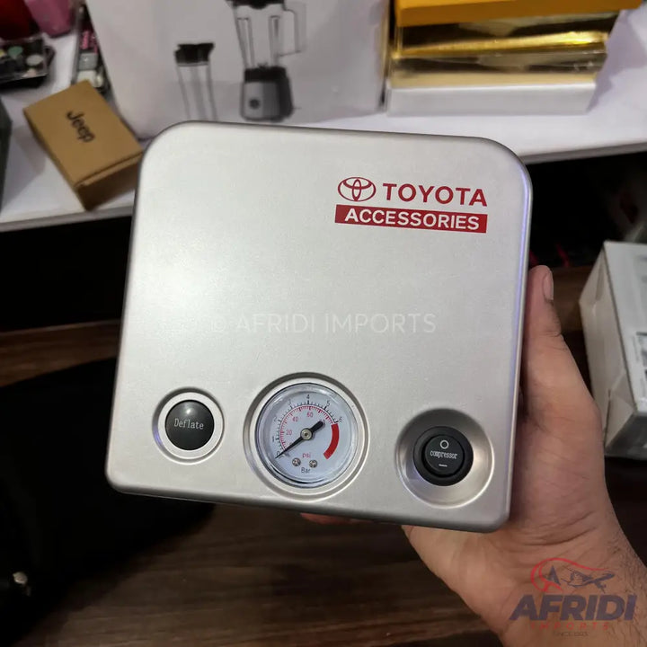 Silver portable tire inflator with a pressure gauge and two control buttons.