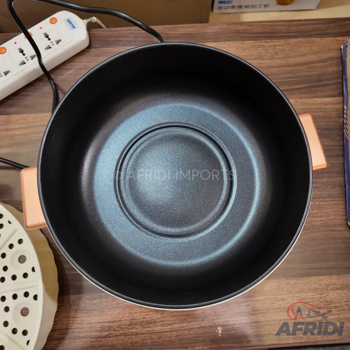 Black electric hot pot with two light brown handles and a round heating element.