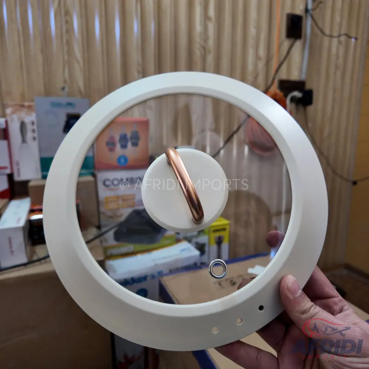 Round glass pot lid with a white rim and a copper-colored handle.