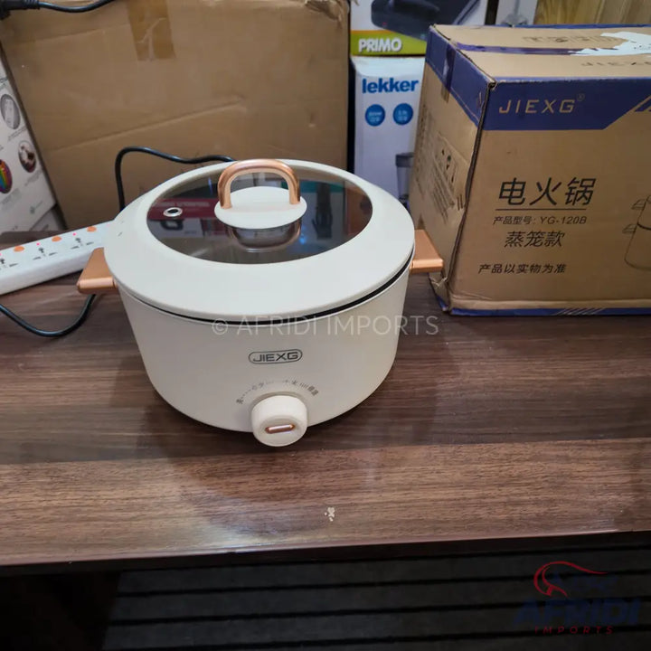 White electric cooking pot with a glass lid and rose gold accents.