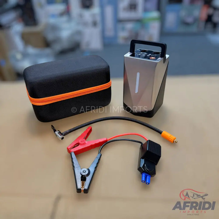 Portable car jump starter kit with air compressor and battery clamps.