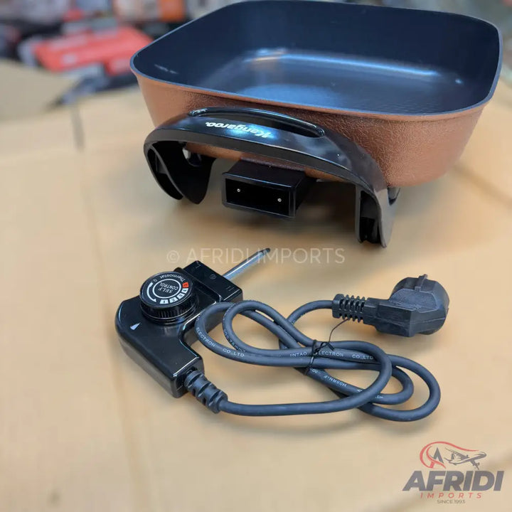 An electric skillet with a temperature control probe and power cord.