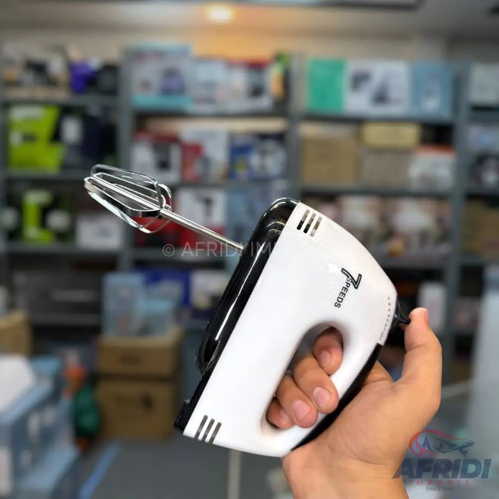 A white and black hand mixer with a single whisk attachment.