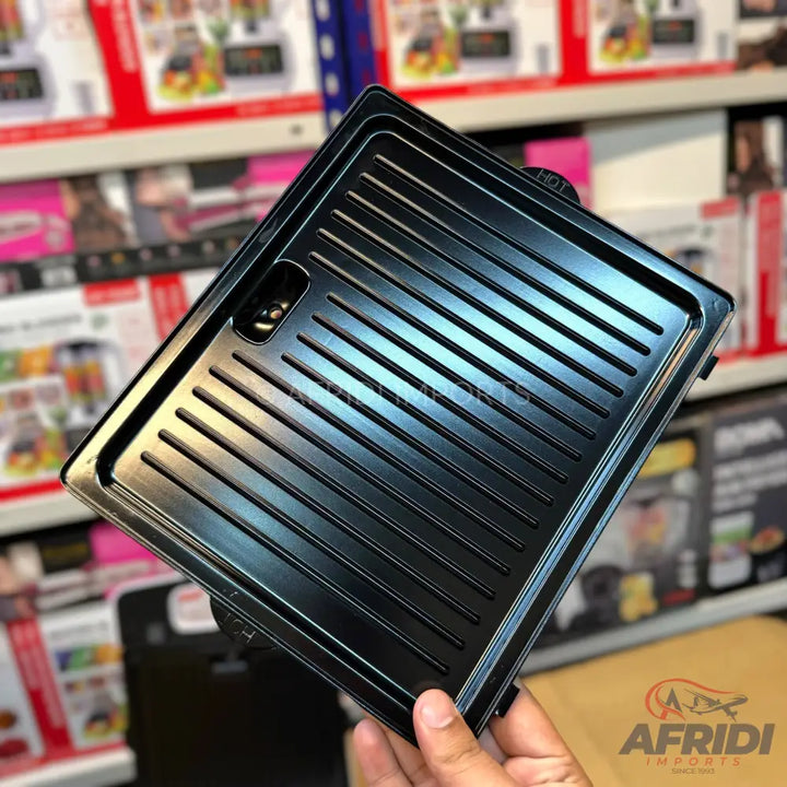 Black rectangular electric grill plate with ridged surface.