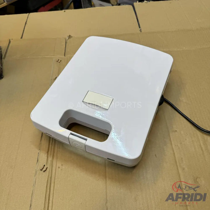 White electric sandwich maker with a rectangular shape and a latch closure.