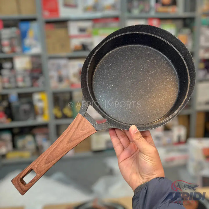 Black non-stick frying pan with a wooden handle.
