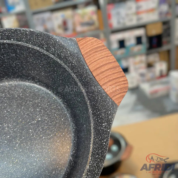 Black speckled non-stick saucepan with a wooden handle.