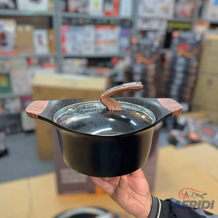 A black cooking pot with a glass lid and wood-grain handles.