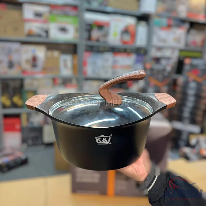 Black cooking pot with a glass lid and wooden handles.