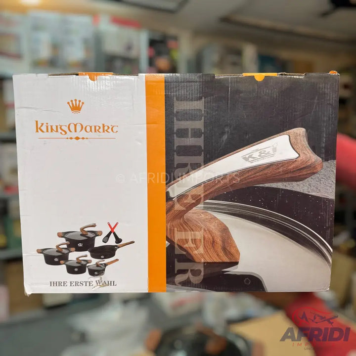 A set of black cookware with wooden handles and matching utensils, packaged in a white and orange box.
