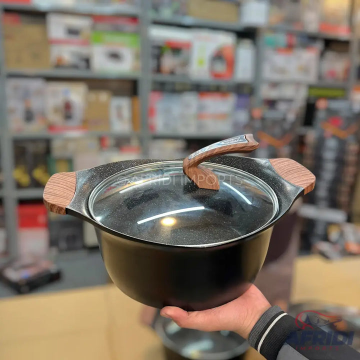 Black non-stick cooking pot with a glass lid and wooden handles.