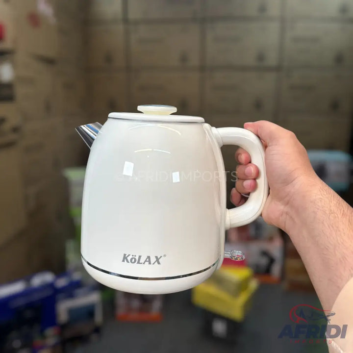 A white electric kettle with a handle and a spout.