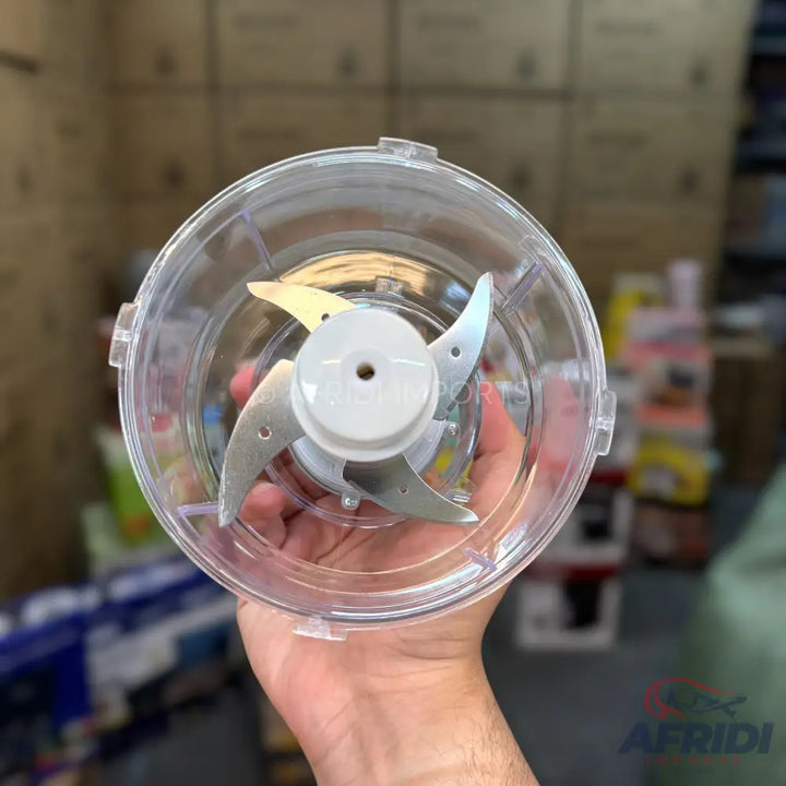 A transparent food processor bowl with a three-bladed chopping attachment.