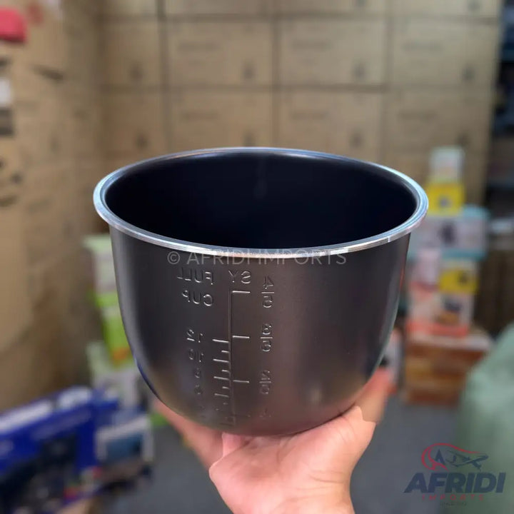 A dark gray non-stick inner cooking pot with volume markings.