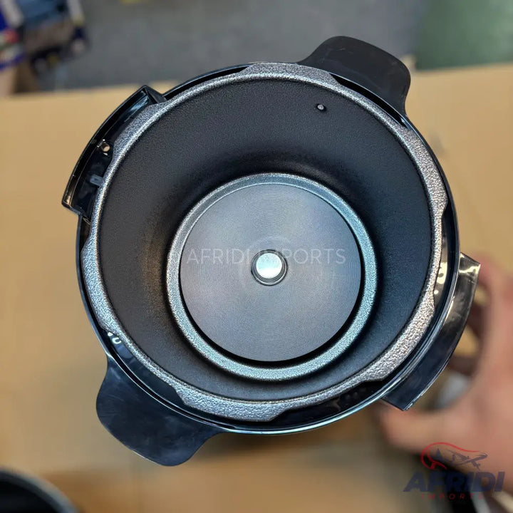 An empty, black, non-stick rice cooker pot with a silver heating element at the bottom.