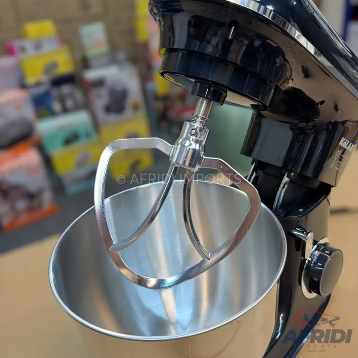 Black stand mixer with a stainless steel bowl and a flat beater attachment.