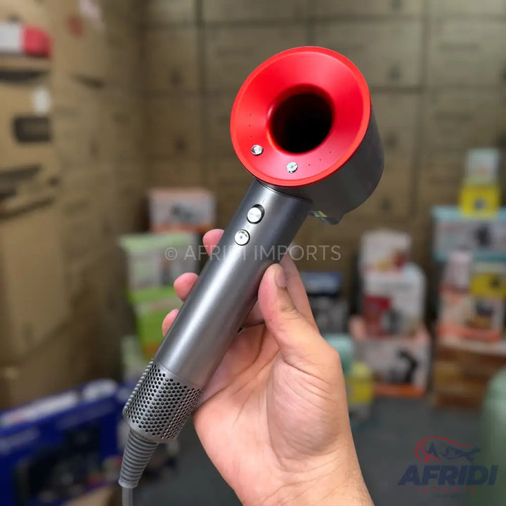 A gray and red handheld hair dryer with a perforated handle.